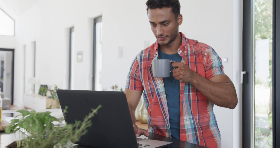 Man Drinking Coffee While Working on Laptop in Modern Home Office - Free Images, Stock Photos and Pictures on Pikwizard.com