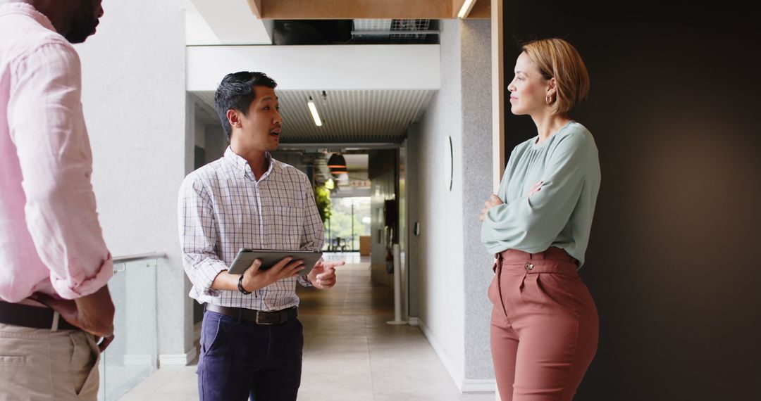 Modern Business Team Collaborating with Tablet in Office Hallway