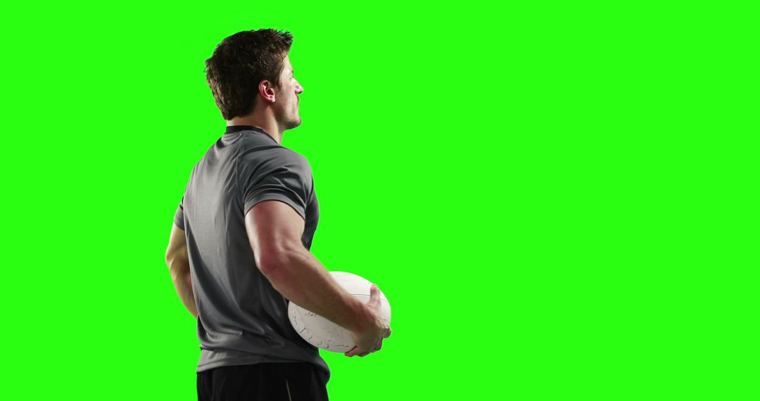 Athlete Holding Rugby Ball with Green Background and Copy Space