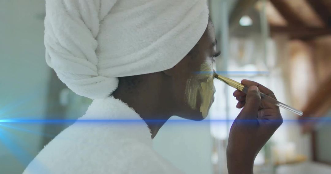 Woman Applying Gold Facial Mask in Spa-Like Setting