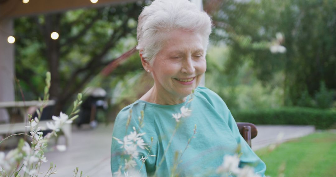 Senior Woman Smiling Outdoors in Garden on a Sunny Day - Free Images, Stock Photos and Pictures on Pikwizard.com