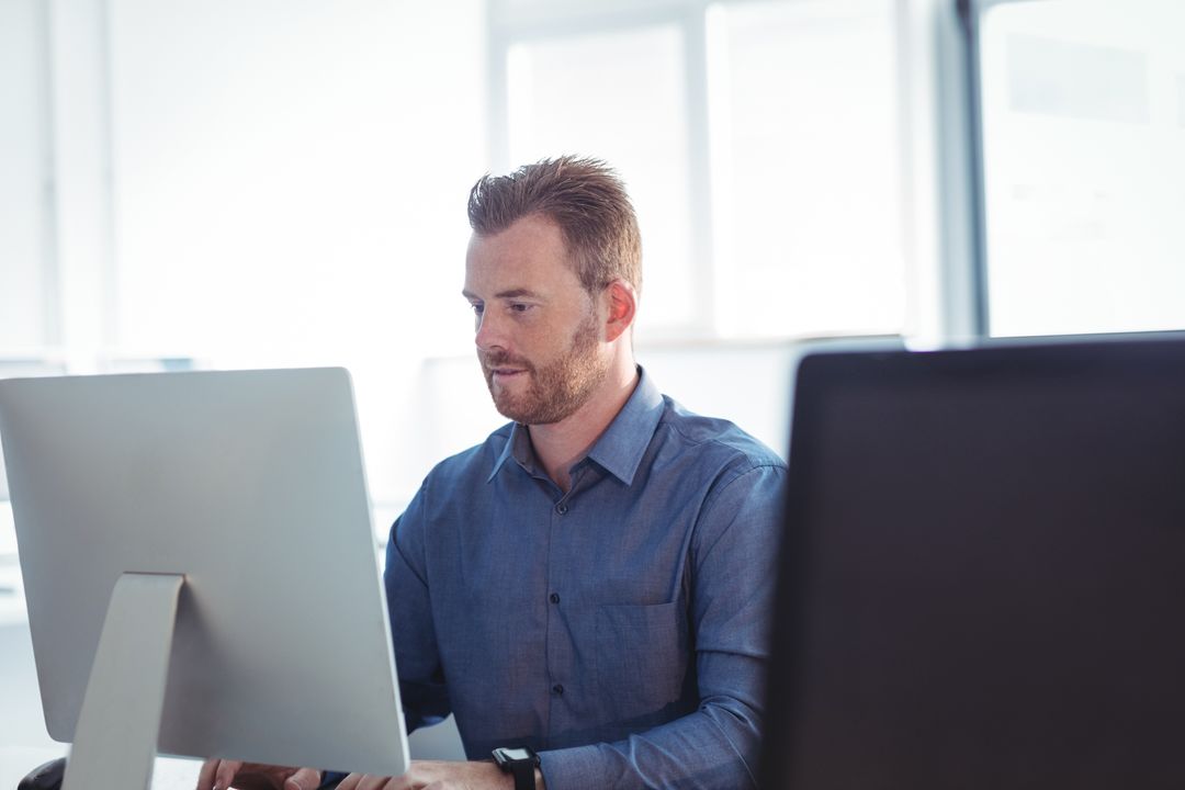 Professional Working at Computer in Bright Modern Office with Windows