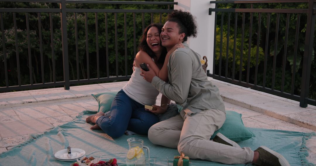 Romantic Rooftop Picnic Moment with Happy Couple at Sunset