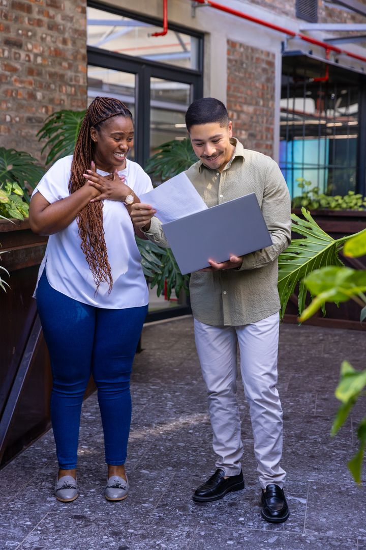 Professional Team Reviewing Documents in Modern Courtyard