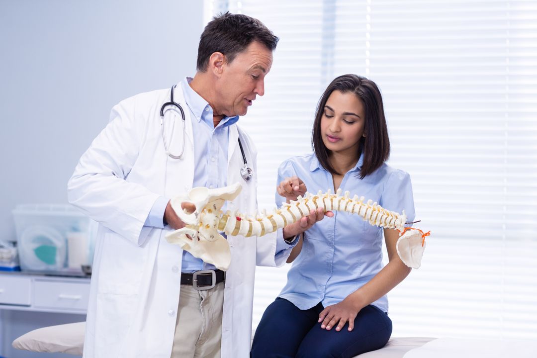Physiotherapist explaining spine model to patient - Free Images, Stock Photos and Pictures on Pikwizard.com