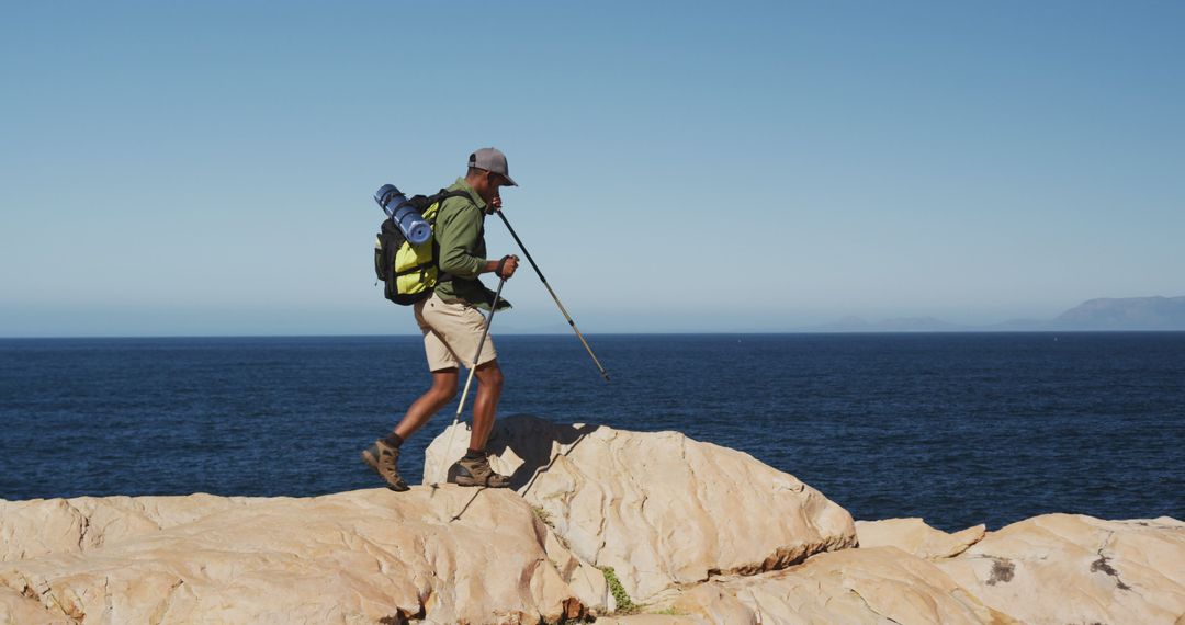 Hiker with Backpack Walking on Cliff Near Ocean - Free Images, Stock Photos and Pictures on Pikwizard.com