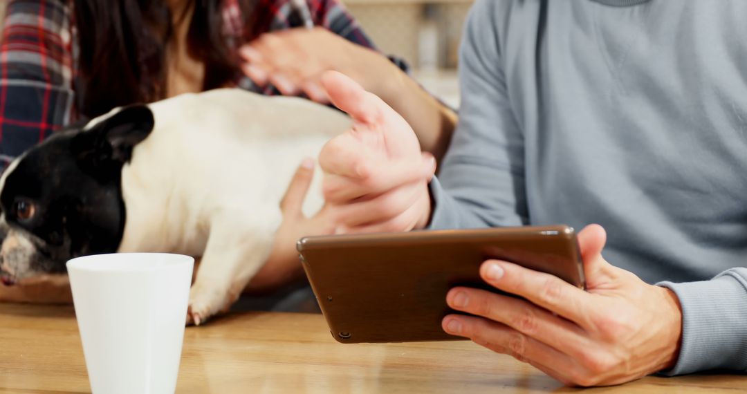 Couple Using Tablet Relaxing at Home with Pet Dog
