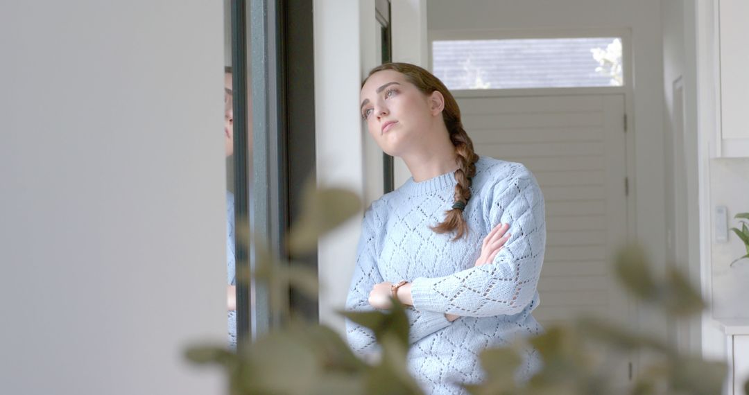 Thoughtful Woman Looking Out Window in Cozy Home Setting - Free Images, Stock Photos and Pictures on Pikwizard.com