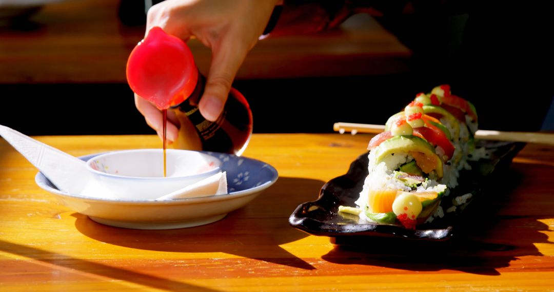 Close-Up Shot of Pouring Soy Sauce Over Sushi Rolls on Wooden Table - Free Images, Stock Photos and Pictures on Pikwizard.com