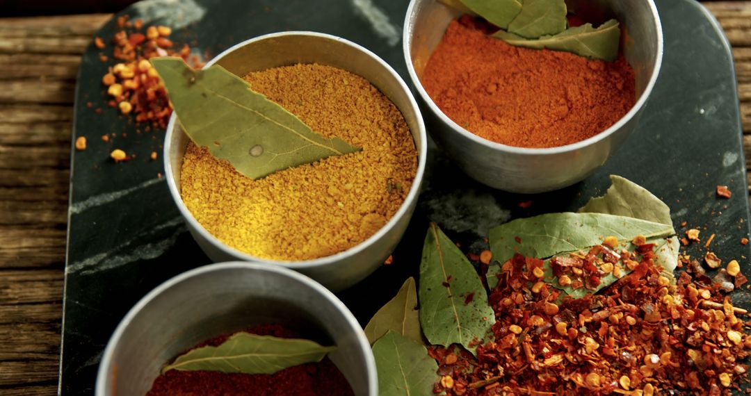 Assorted Ground Spices and Bay Leaves in Steel Containers on Rustic Wooden Table - Free Images, Stock Photos and Pictures on Pikwizard.com