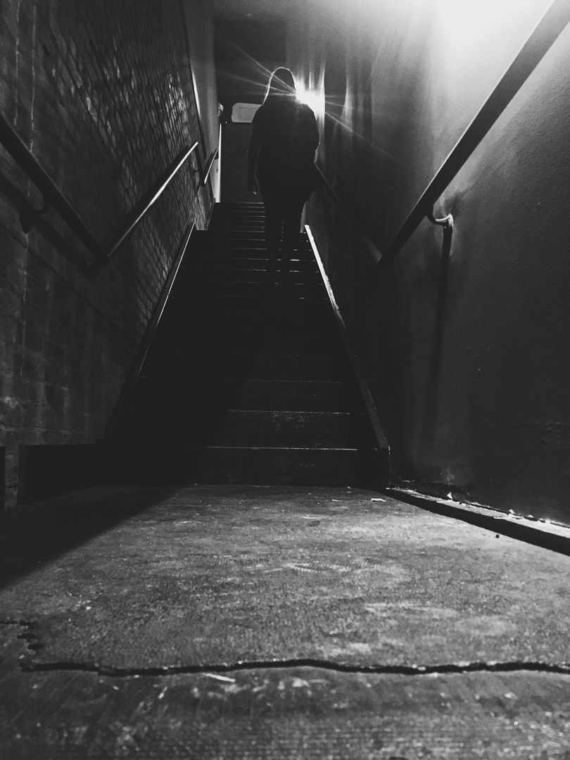 Silhouetted Person Climbing Dark Staircase - Free Images, Stock Photos and Pictures on Pikwizard.com