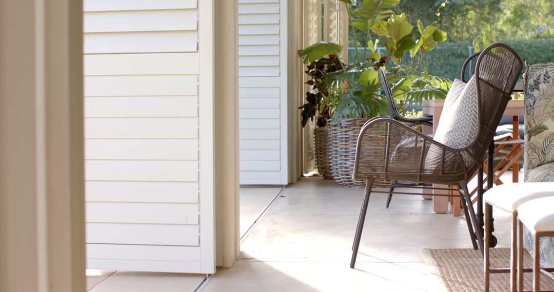 Cozy Sunny Porch with Wicker Chairs and Lush Greenery