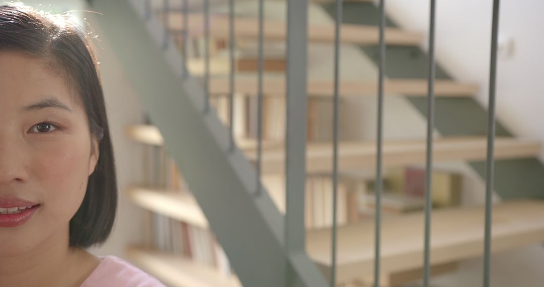 Modern Interior Design Featuring Staircase Bookshelves and Smiling Asian Woman