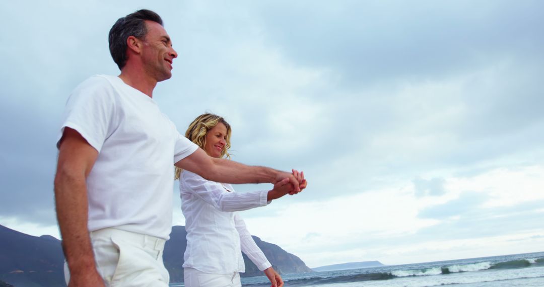 Smiling Mature Couple Walking on Beach Holding Hands - Free Images, Stock Photos and Pictures on Pikwizard.com