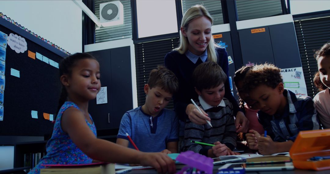 Engaged Teacher Counseling Diverse Children in Classroom with Technology Concept