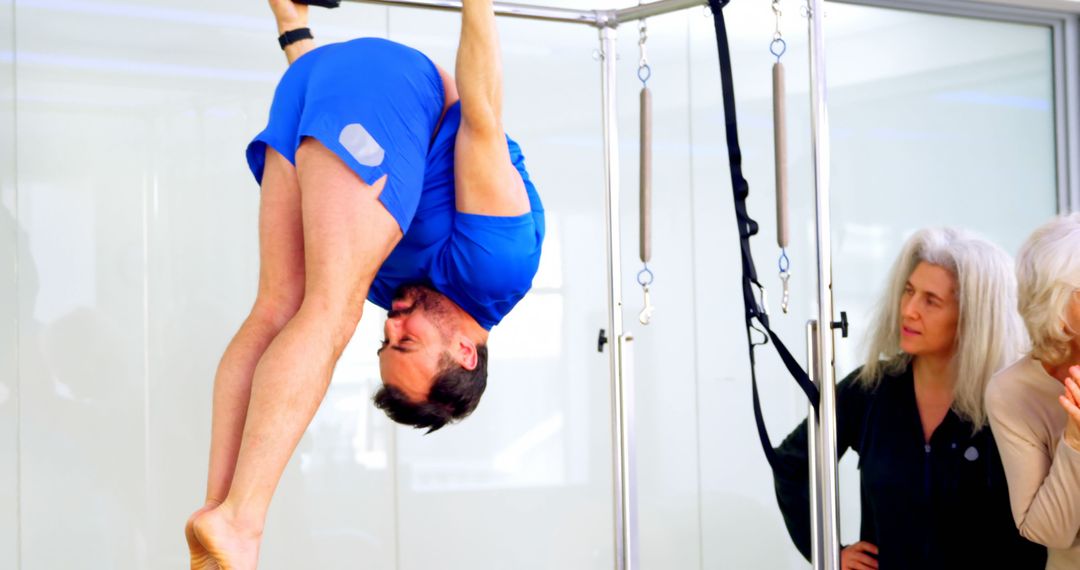 Man Practicing Aerial Pilates with Senior Women Observing - Free Images, Stock Photos and Pictures on Pikwizard.com