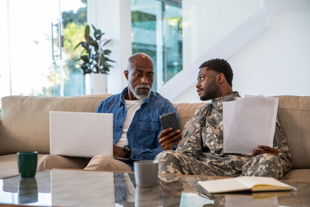 Father and Son Collaborating on Military Documents at Home