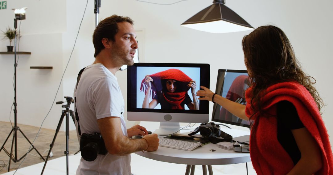 Photographer and Model Reviewing Photos on Computer in Studio