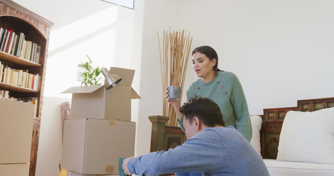 Couple Joyfully Unpacking in New Home Surrounded by Boxes