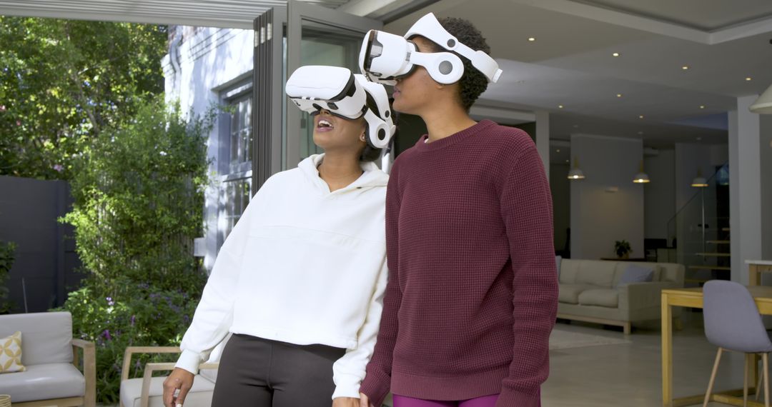 Two Diverse Friends Using VR Headsets at Patio Entrance