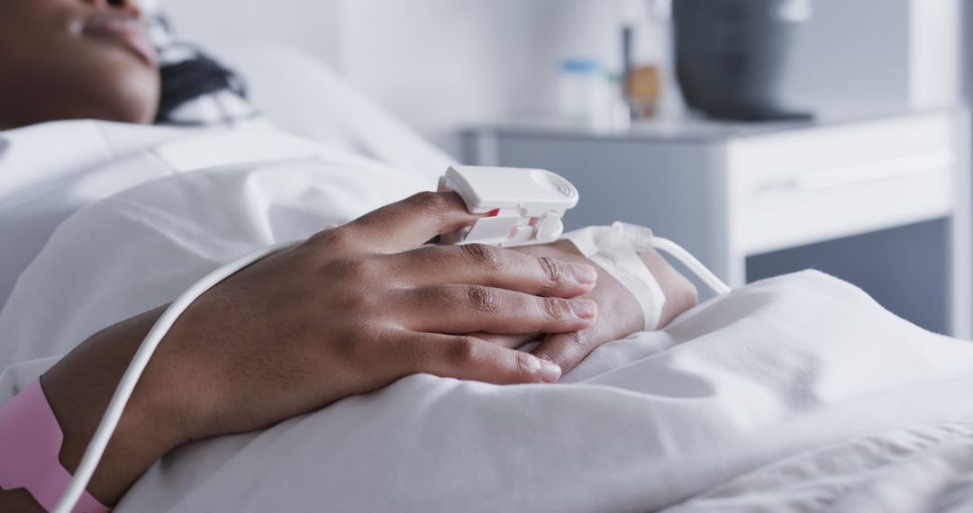 Patient resting in hospital bed with pulse oximeter on hand - Free Images, Stock Photos and Pictures on Pikwizard.com