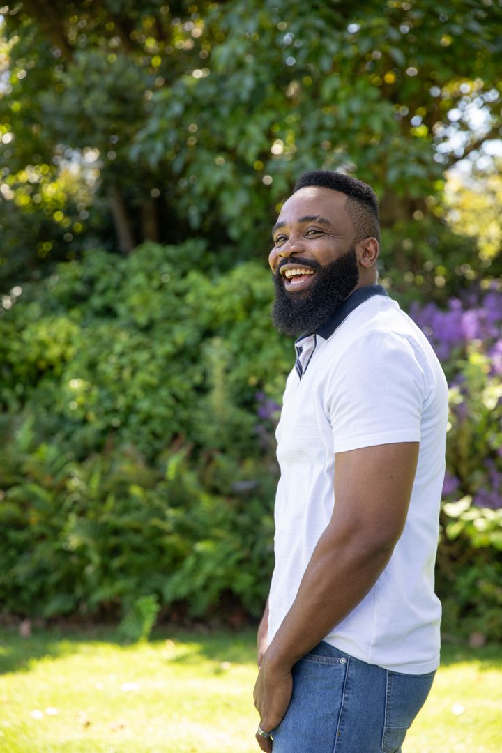 Joyful African American Man Laughing in Sunny Park Setting