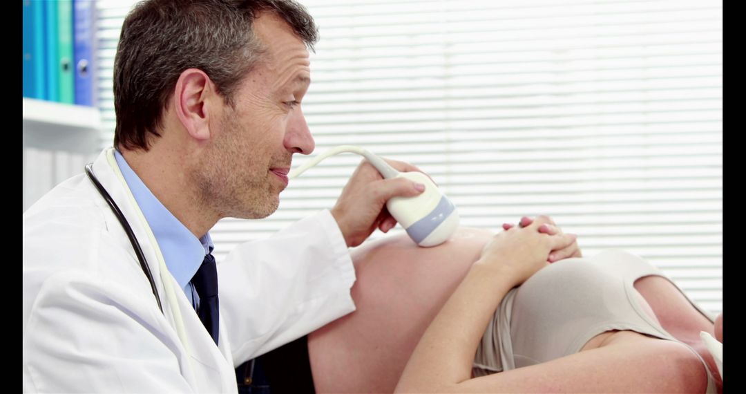 Doctor performing ultrasound on pregnant woman smiling - Free Images, Stock Photos and Pictures on Pikwizard.com