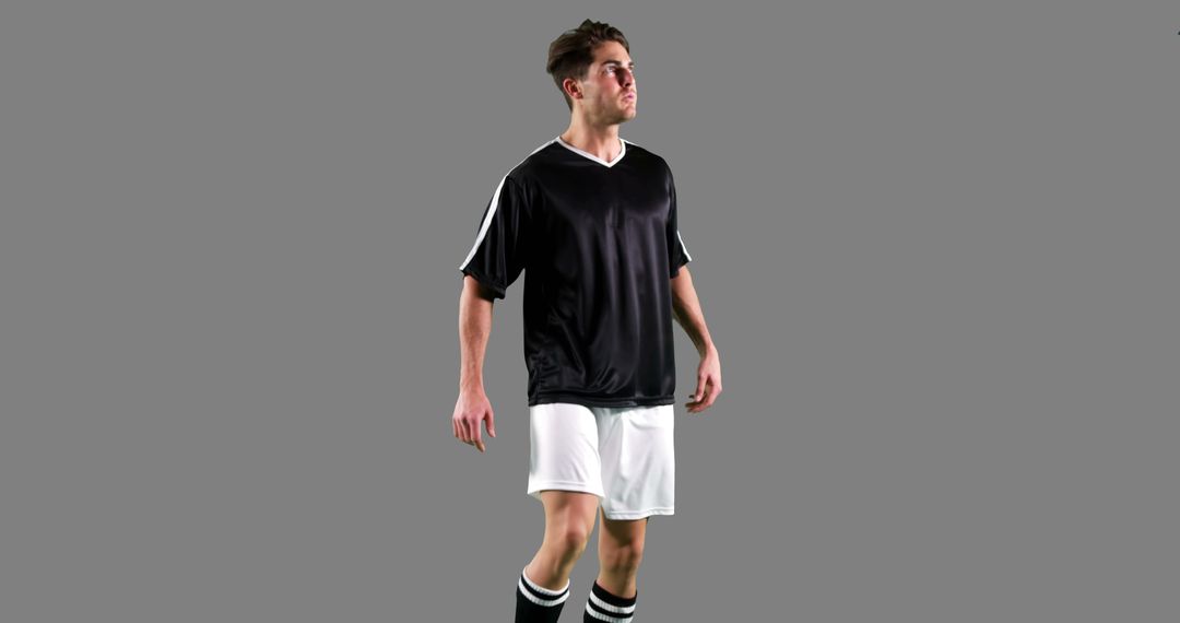 Focused Soccer Player in Action Against Gray Background