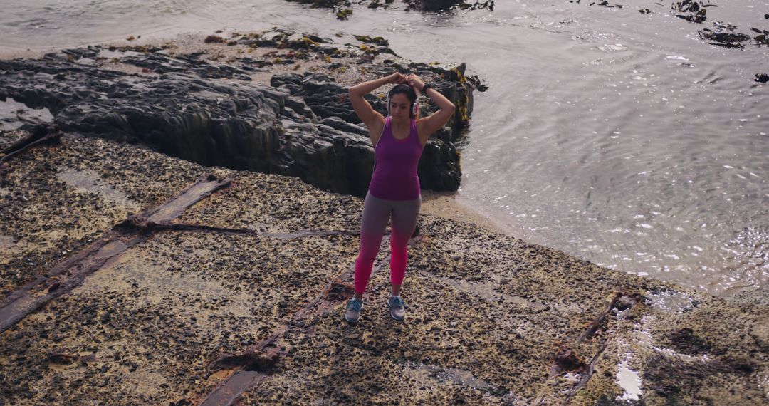 Active Woman Stretching on Rocky Shoreline - Free Images, Stock Photos and Pictures on Pikwizard.com