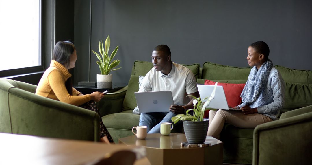 Diverse Team Collaborating in Modern Office Lounge with Laptops
