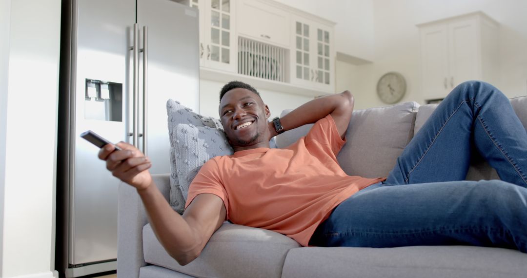 Relaxing Young African American Man Enjoying TV at Home - Free Images, Stock Photos and Pictures on Pikwizard.com