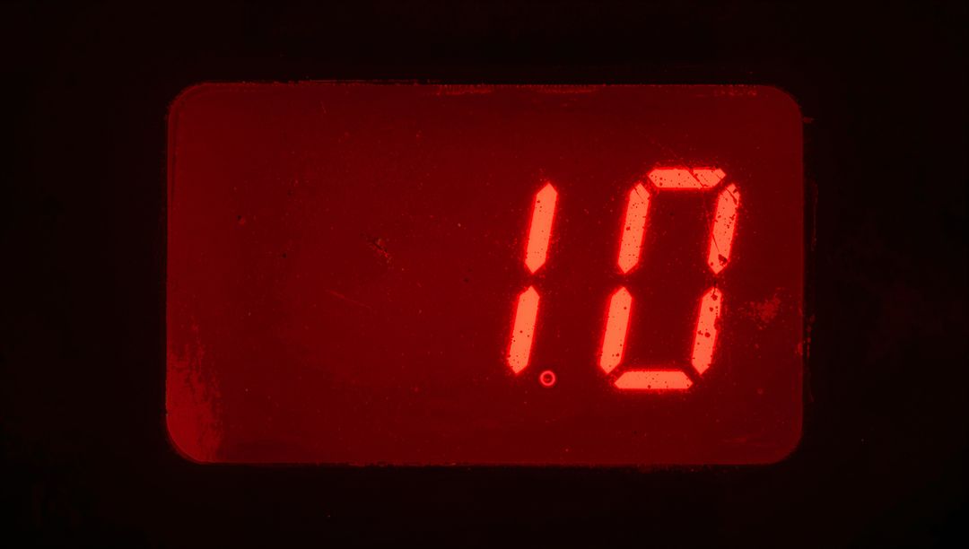 Red LED Seven-Segment Display Displaying 10 With Scratched Window and Glowing Point