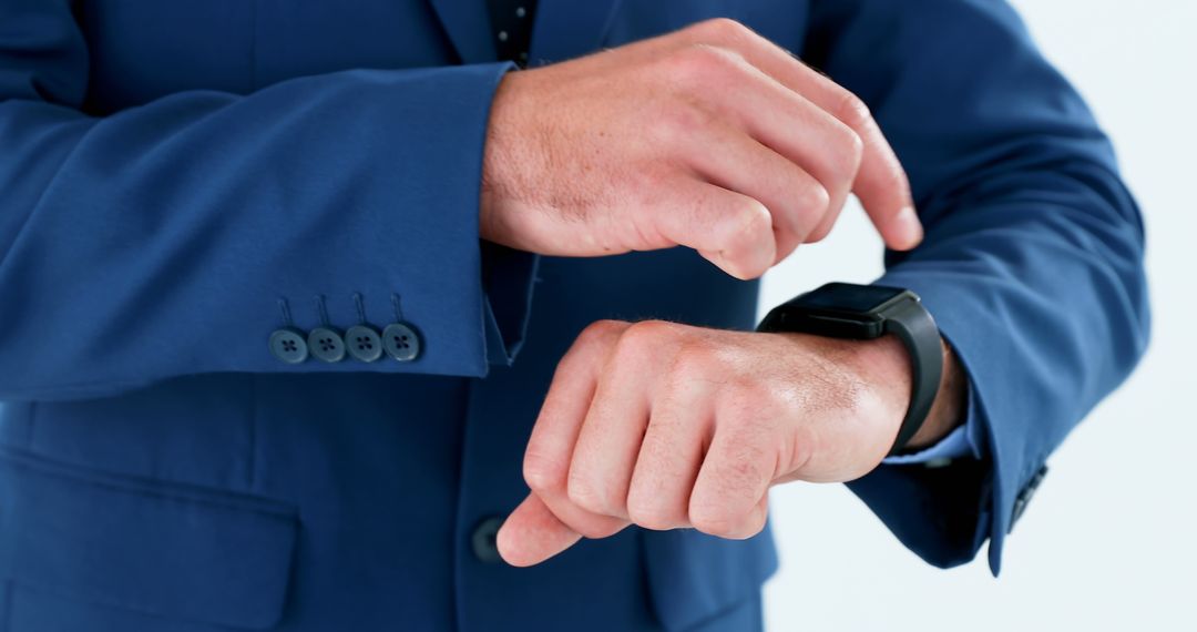 Businessman Checking Time on Smartwatch in Blue Suit - Free Images, Stock Photos and Pictures on Pikwizard.com