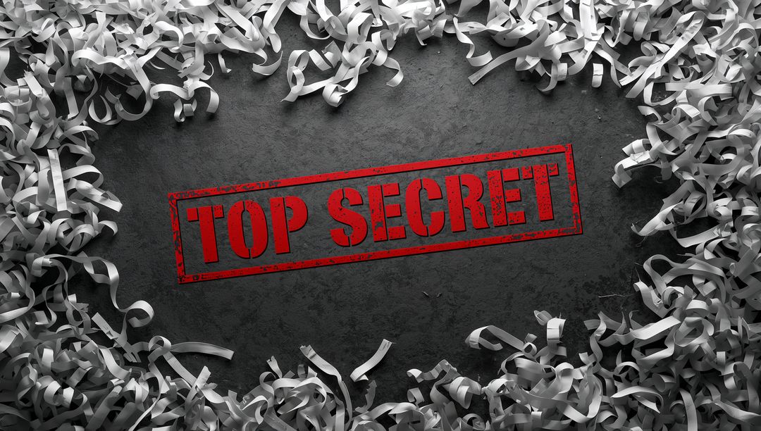 Top Secret Red Stamp on Dark Textured Surface Surrounded by Shredded Paper