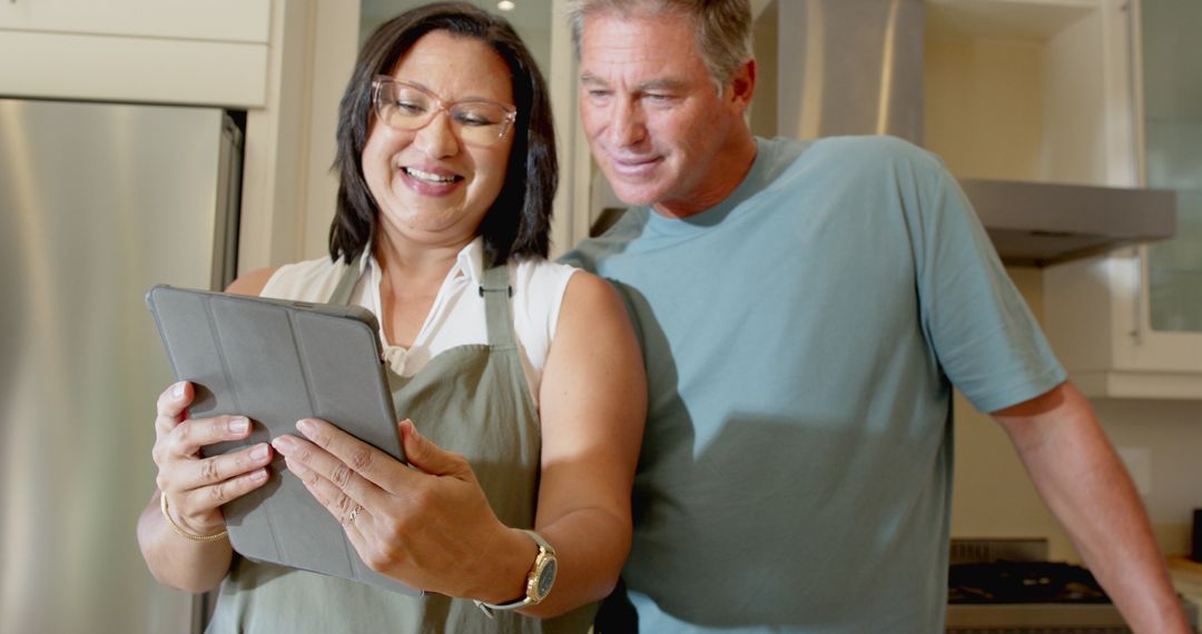 Diverse Couple Using Tablet for Cooking in Modern Kitchen