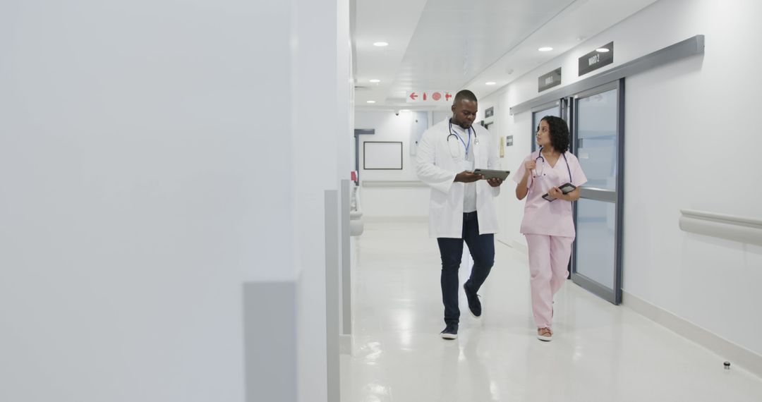 Healthcare Providers Reviewing Medical Records in Hospital Corridor - Free Images, Stock Photos and Pictures on Pikwizard.com