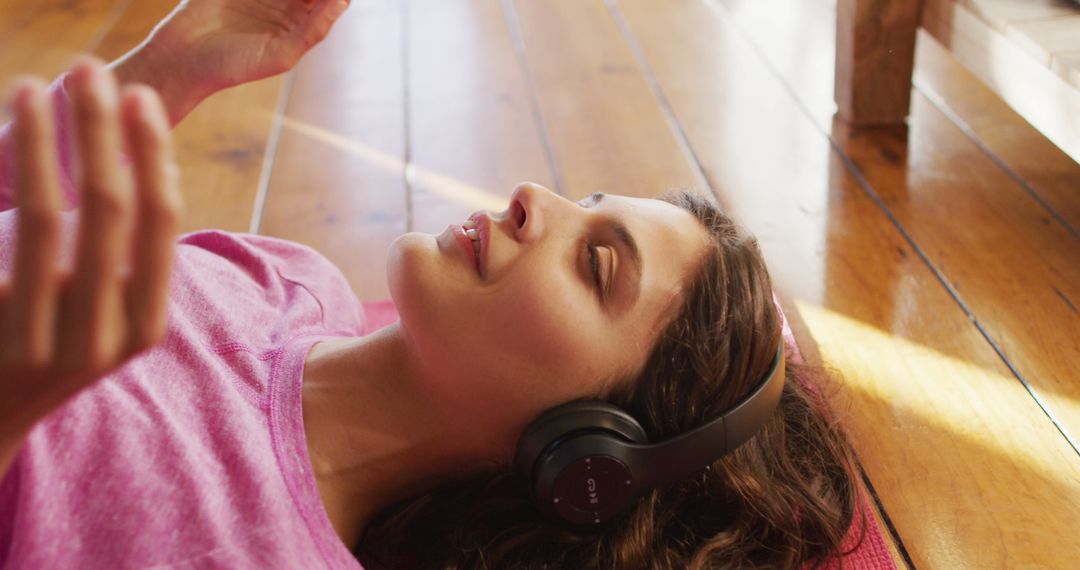 Young Woman Relaxing with Headphones on Wood Floor, Enjoying Music - Free Images, Stock Photos and Pictures on Pikwizard.com