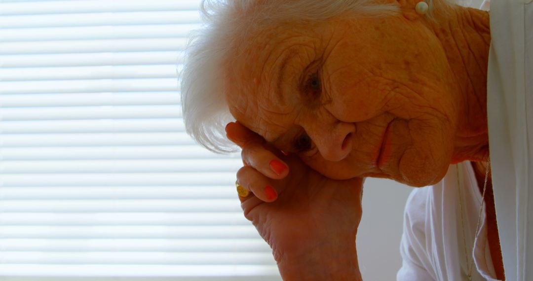 Elderly Woman Contemplating by Window Light - Free Images, Stock Photos and Pictures on Pikwizard.com