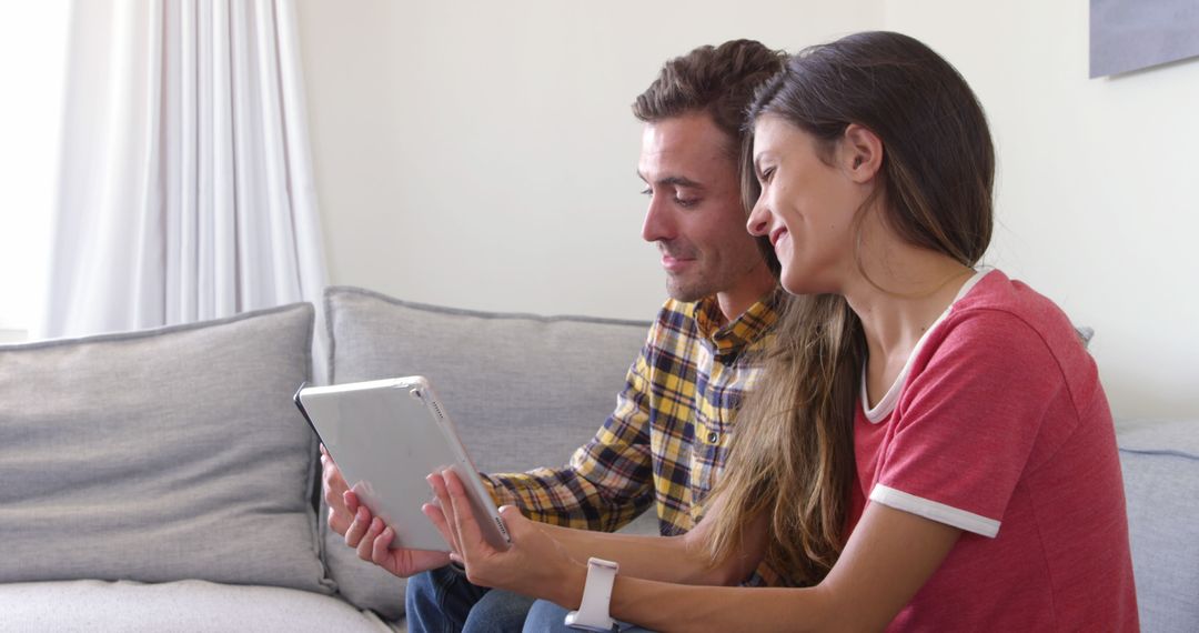 Couple Enjoying Tablet on Cozy Couch in Relaxed Home Setting