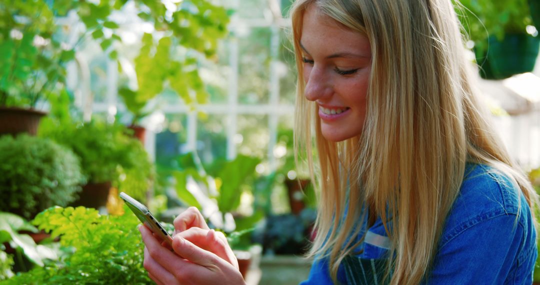 Young Woman Using Smartphone in Greenhouse Garden - Free Images, Stock Photos and Pictures on Pikwizard.com