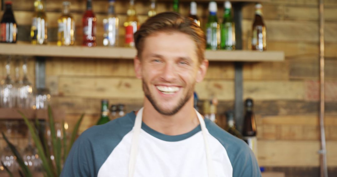 Smiling Bartender Wearing Apron in Front of Bar - Free Images, Stock Photos and Pictures on Pikwizard.com