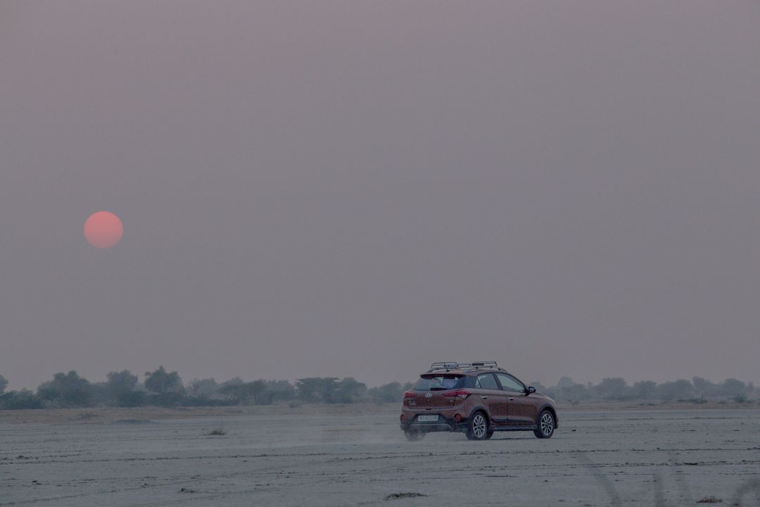 SUV Exploring Desert at Sunrise with Pink Hues - Free Images, Stock Photos and Pictures on Pikwizard.com