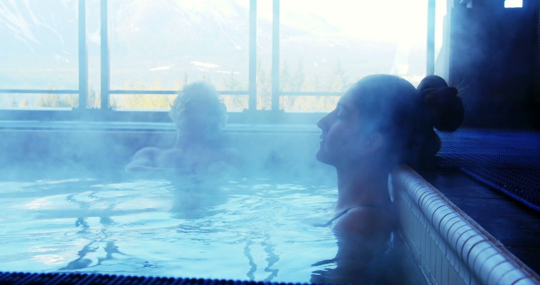 A woman unwinds in a hot tub at a scenic spa with a companion and mountain backdrop. - Free Images, Stock Photos and Pictures on Pikwizard.com