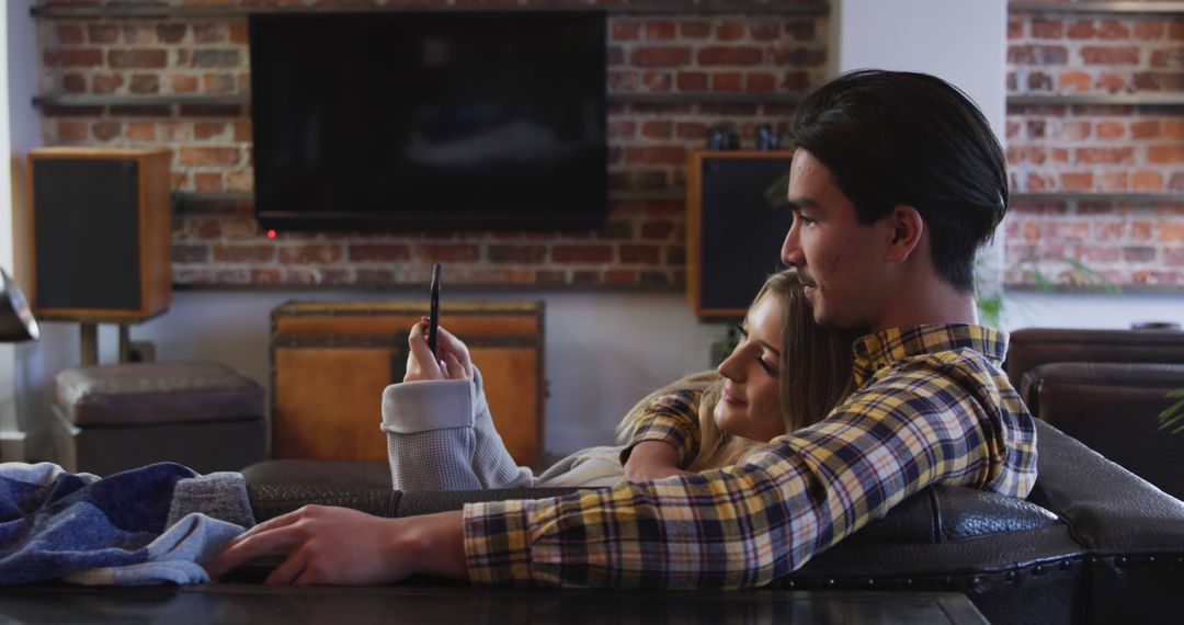 Couple Using Smartphone Relaxing on Couch in Cozy Living Room