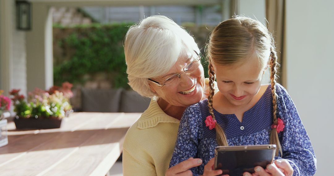 Happy Grandmother Bonding with Granddaughter Through Tablet - Free Images, Stock Photos and Pictures on Pikwizard.com