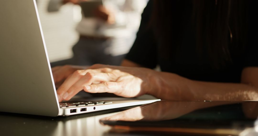 Hands Typing on Laptop in Modern Office Environment