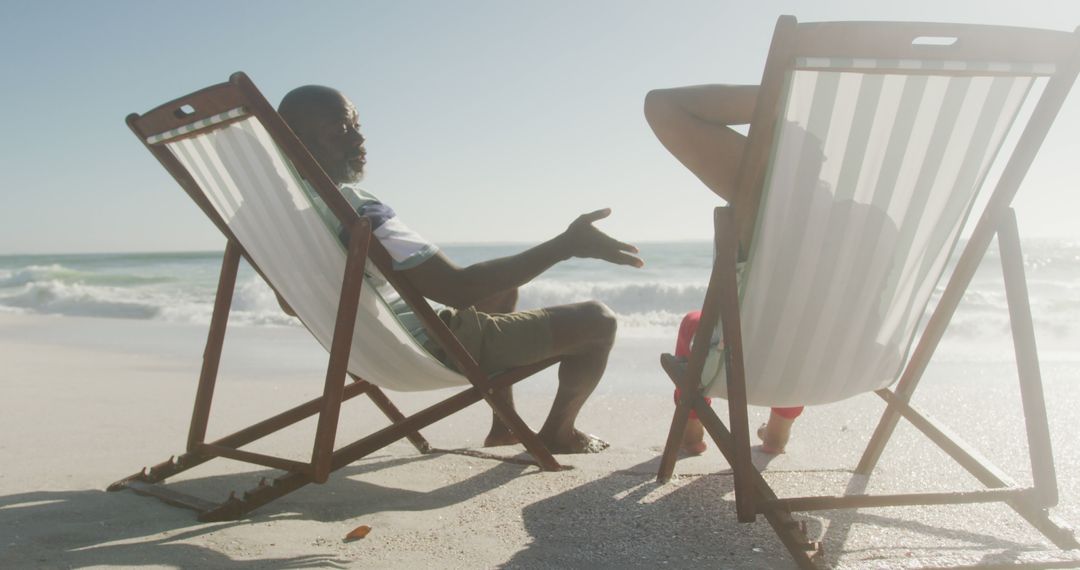 Two People Relaxing in Deck Chairs on Beach at Sunset - Free Images, Stock Photos and Pictures on Pikwizard.com