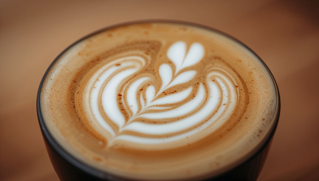 Ceramic Cup Latte with Rosetta Latte Art, Velvety Microfoam and Cinnamon Specks Closeup