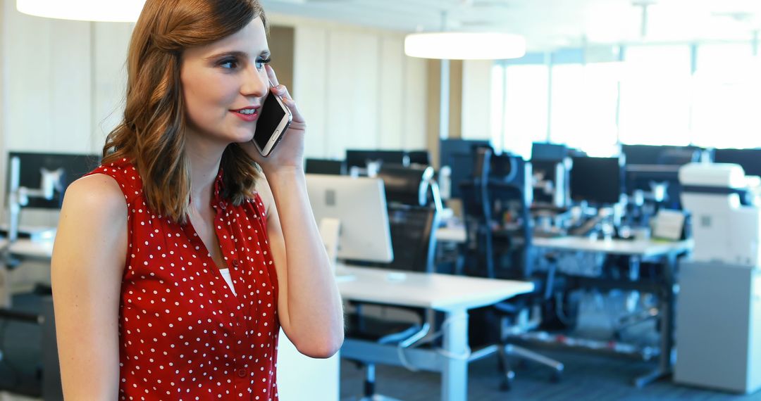 Woman in Red Polka Dot Shirt Talking on Smartphone in Modern Office - Free Images, Stock Photos and Pictures on Pikwizard.com