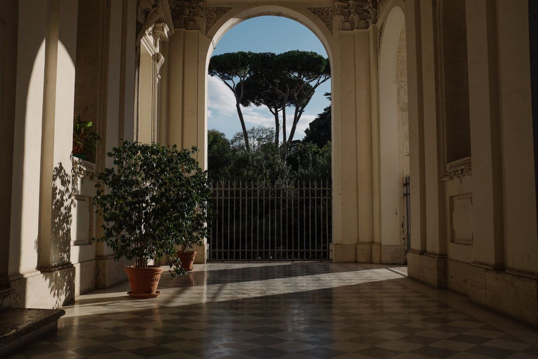 Historic Italian Building Corridor with Classic Arch and Trees - Free Images, Stock Photos and Pictures on Pikwizard.com